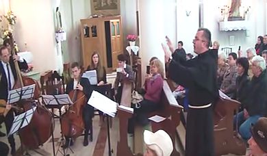 părintele paroh Cristian Dumea dirijând corul și orchestra la Galați